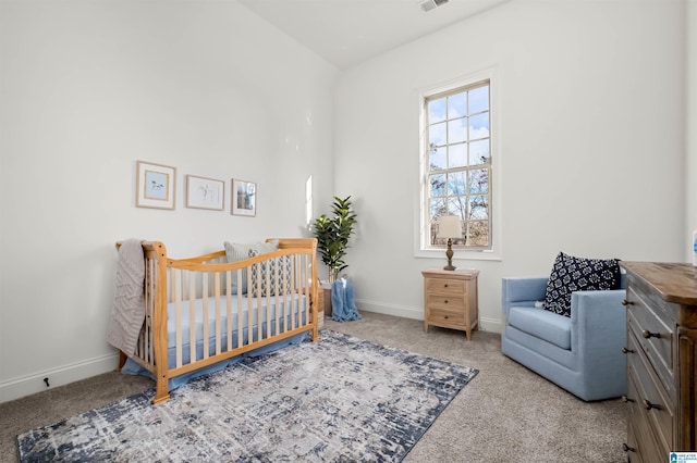 carpeted bedroom featuring a crib and vaulted ceiling