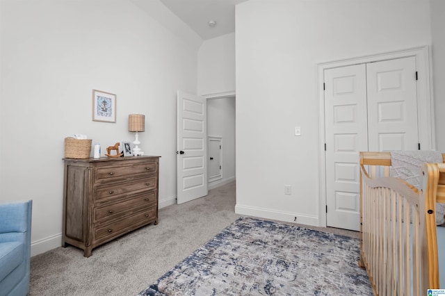 carpeted bedroom featuring high vaulted ceiling and a closet