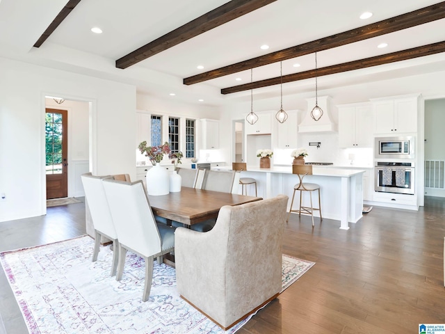 dining room featuring beam ceiling and dark hardwood / wood-style flooring