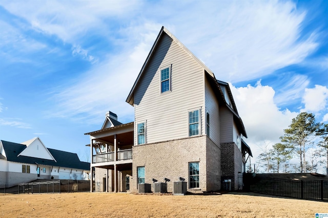 back of house featuring cooling unit and a balcony