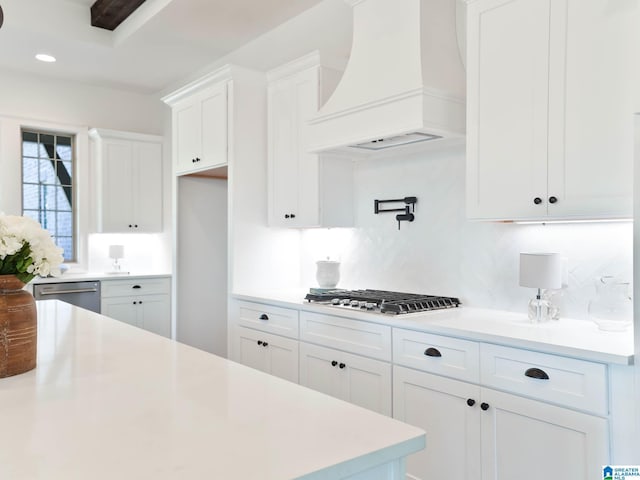 kitchen featuring white cabinets, backsplash, custom range hood, and stainless steel appliances