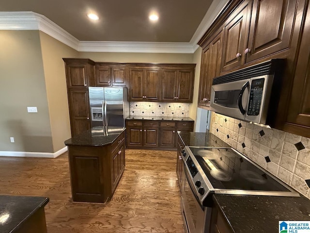 kitchen featuring dark brown cabinetry, decorative backsplash, crown molding, and appliances with stainless steel finishes