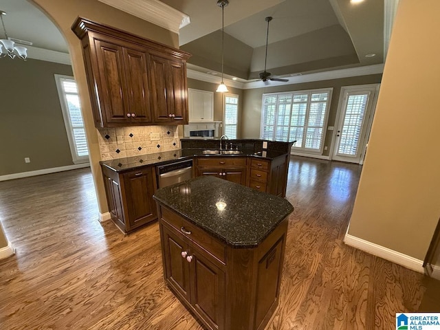 kitchen featuring a raised ceiling, ceiling fan, sink, hardwood / wood-style flooring, and a center island