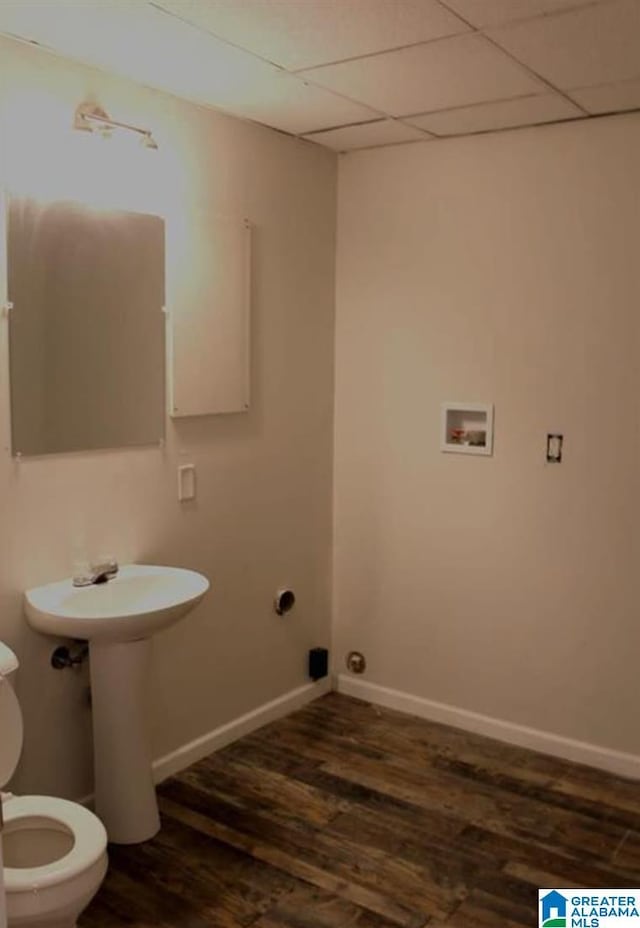 bathroom with wood-type flooring, a paneled ceiling, and toilet