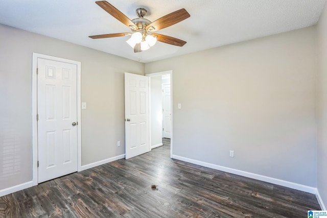 unfurnished bedroom featuring ceiling fan and dark hardwood / wood-style floors