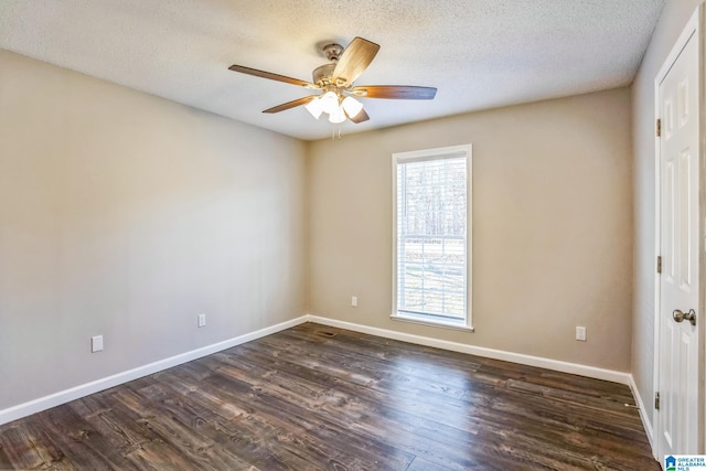 empty room featuring a textured ceiling, plenty of natural light, and dark wood-type flooring