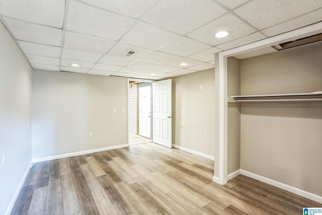 interior space featuring a paneled ceiling, light hardwood / wood-style floors, and a closet