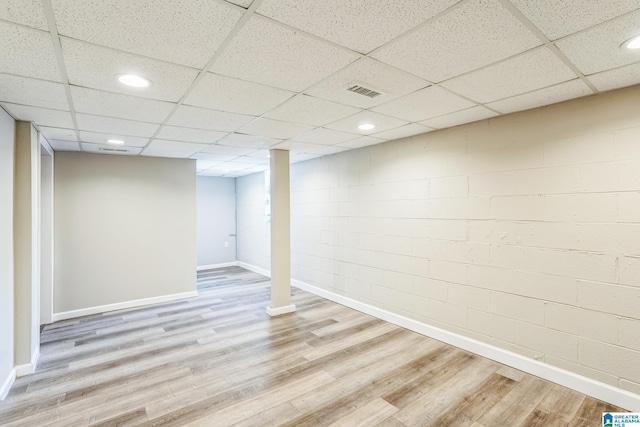 basement with a drop ceiling and light wood-type flooring