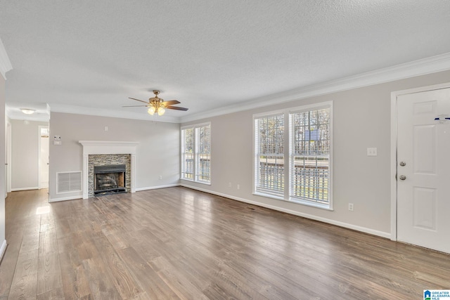 unfurnished living room with a fireplace, a wealth of natural light, ornamental molding, and ceiling fan