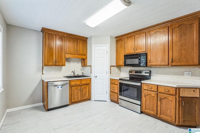 kitchen featuring a textured ceiling, decorative backsplash, sink, and stainless steel appliances