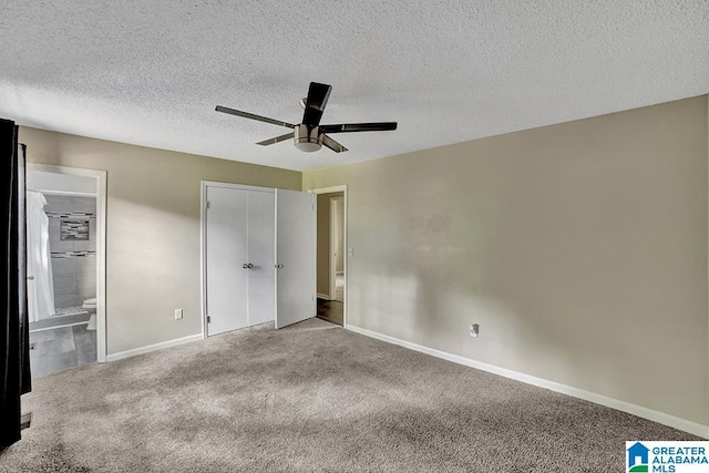 unfurnished bedroom with carpet flooring, ceiling fan, ensuite bathroom, and a textured ceiling