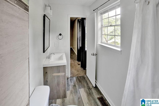 bathroom featuring hardwood / wood-style floors, vanity, and toilet