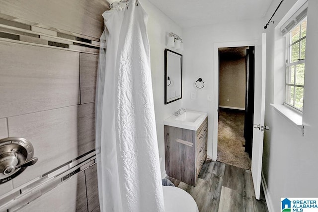 bathroom featuring walk in shower, wood-type flooring, vanity, and a wealth of natural light