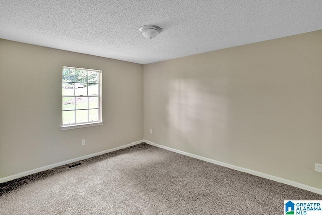 carpeted spare room with a textured ceiling