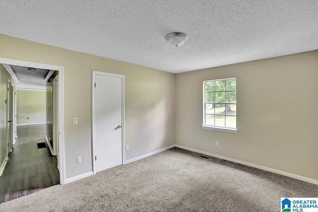 carpeted spare room with a textured ceiling