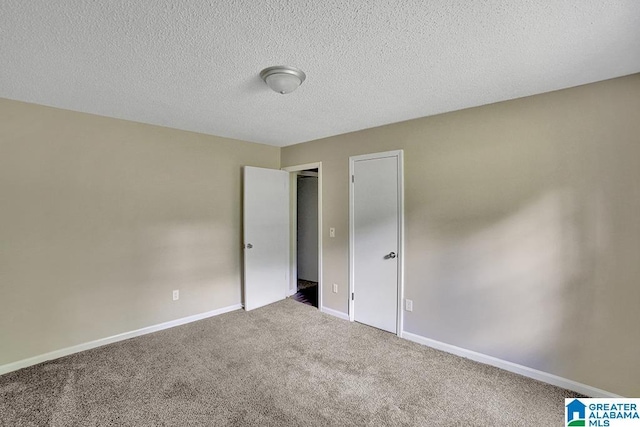 spare room with carpet and a textured ceiling