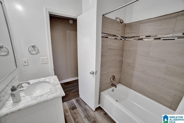 bathroom featuring vanity, wood-type flooring, and tiled shower / bath combo