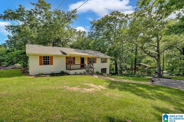 view of front of house with a porch, a garage, and a front lawn