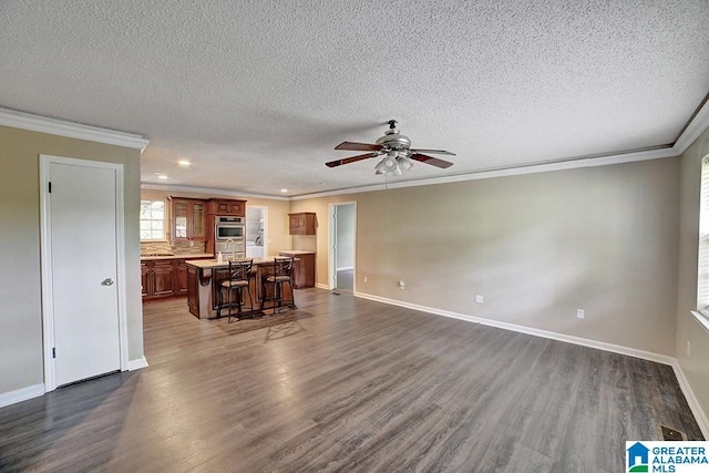 living room with a textured ceiling, dark hardwood / wood-style floors, ceiling fan, and crown molding