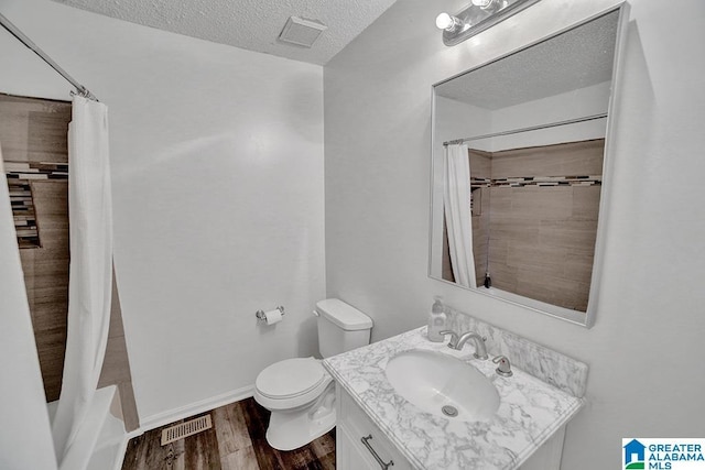 full bathroom with shower / bathtub combination with curtain, wood-type flooring, a textured ceiling, toilet, and vanity