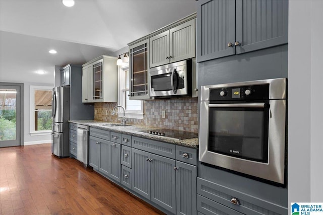 kitchen with sink, decorative backsplash, gray cabinets, and appliances with stainless steel finishes