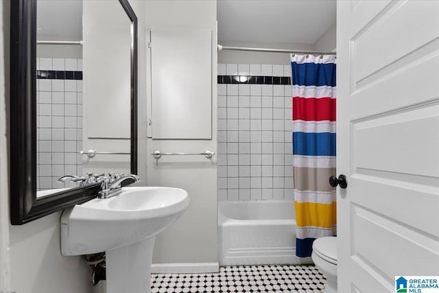 full bathroom featuring sink, shower / bath combo with shower curtain, and toilet