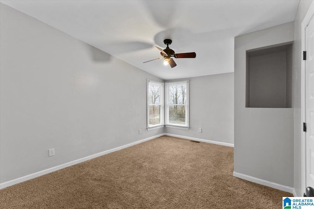 carpeted spare room with ceiling fan and lofted ceiling