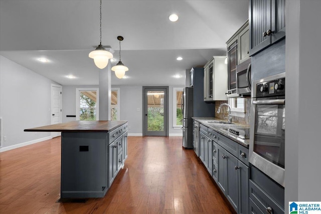 kitchen with butcher block counters, gray cabinets, and appliances with stainless steel finishes