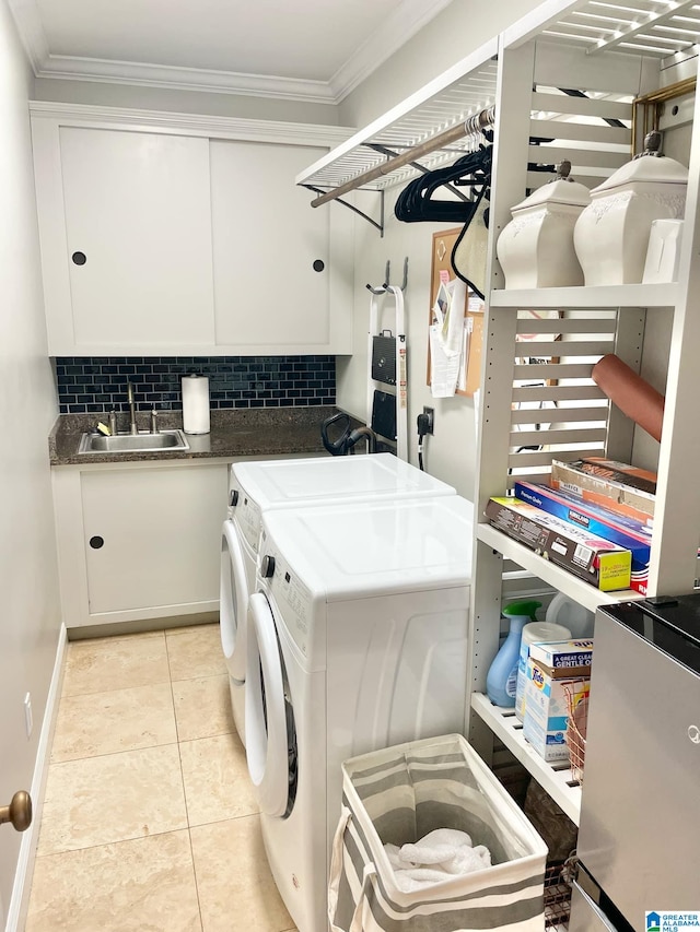 laundry area featuring cabinets, sink, washing machine and dryer, ornamental molding, and light tile patterned flooring