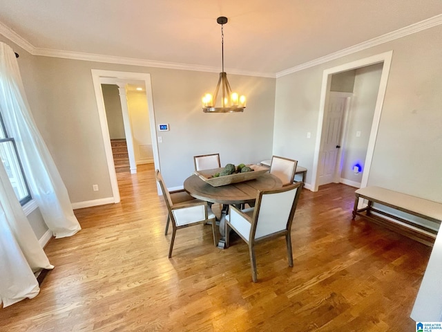 dining area with hardwood / wood-style flooring, crown molding, and an inviting chandelier