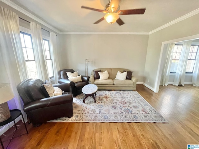 living room featuring wood-type flooring, crown molding, and a wealth of natural light