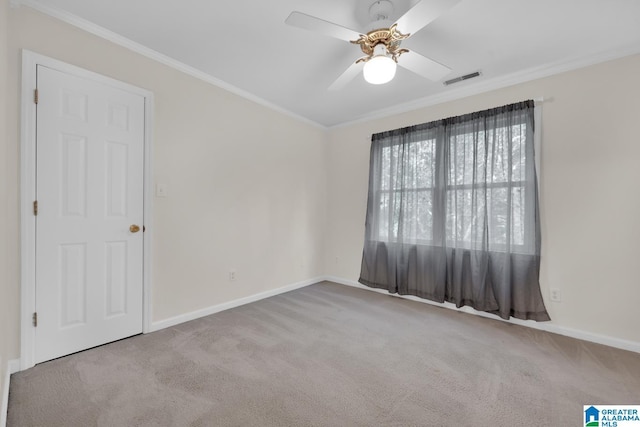 empty room with ceiling fan, light colored carpet, and ornamental molding