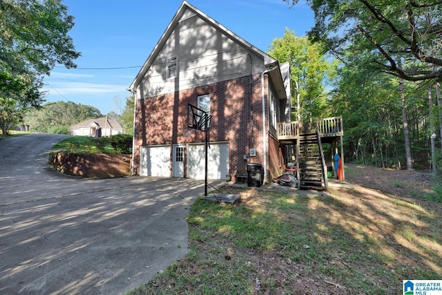 view of property exterior with a garage and a deck