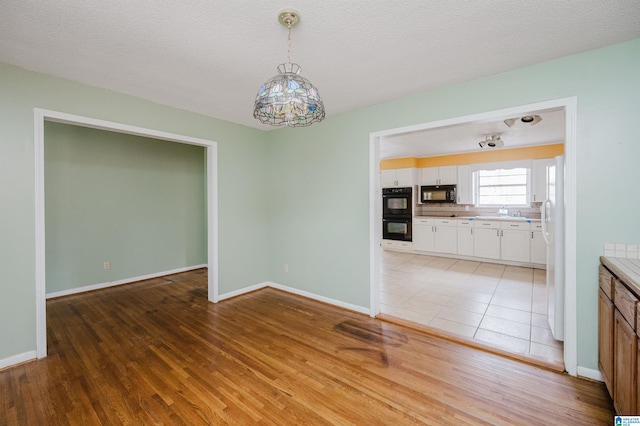 unfurnished dining area featuring hardwood / wood-style flooring and a textured ceiling