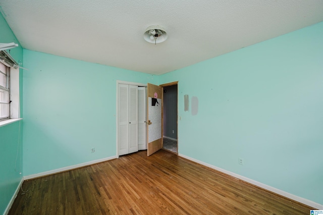 unfurnished bedroom with a closet and hardwood / wood-style flooring