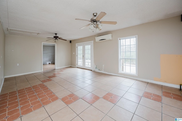 tiled empty room featuring ceiling fan, an AC wall unit, a textured ceiling, and french doors