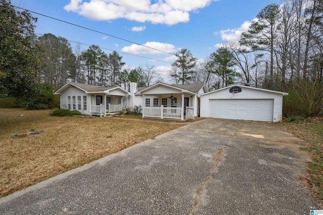 ranch-style house featuring a garage, covered porch, an outbuilding, and a front yard