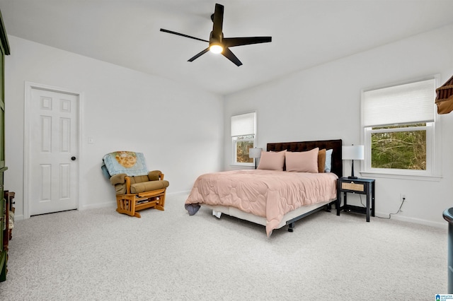 carpeted bedroom with ceiling fan, multiple windows, and baseboards