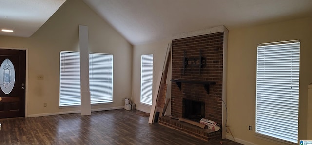 interior space featuring dark hardwood / wood-style flooring, vaulted ceiling, and a brick fireplace