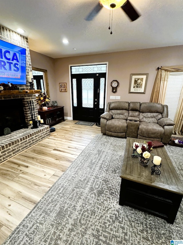 living room with a fireplace, hardwood / wood-style floors, a textured ceiling, and plenty of natural light