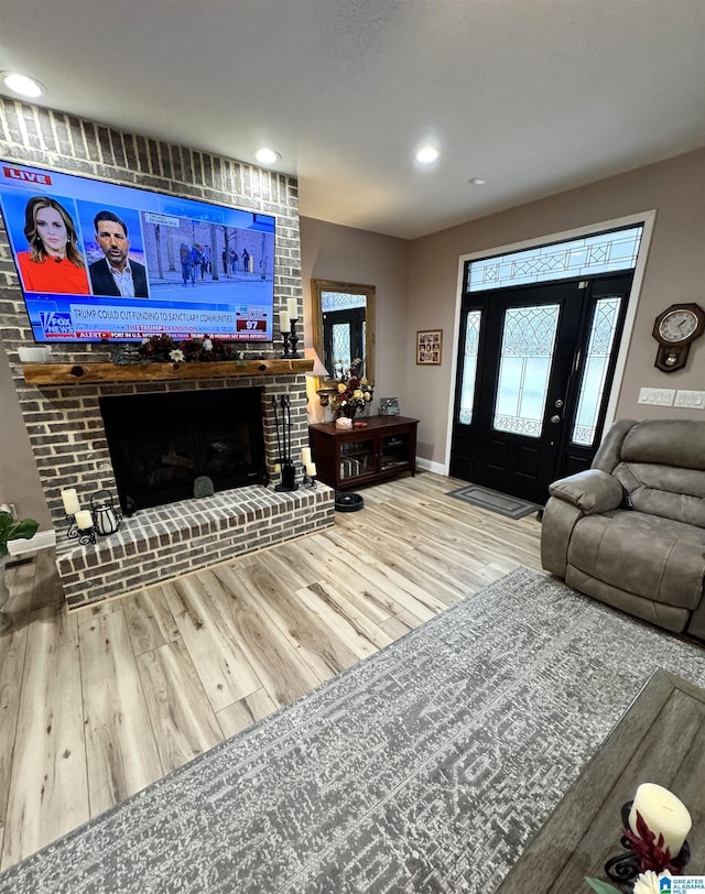 living room featuring hardwood / wood-style flooring and a brick fireplace