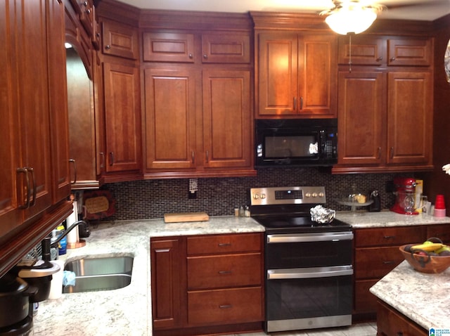 kitchen with tasteful backsplash, light stone counters, sink, and stainless steel range with electric cooktop