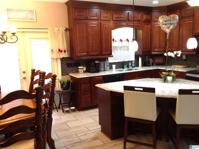 kitchen with pendant lighting, sink, black dishwasher, tasteful backsplash, and a chandelier