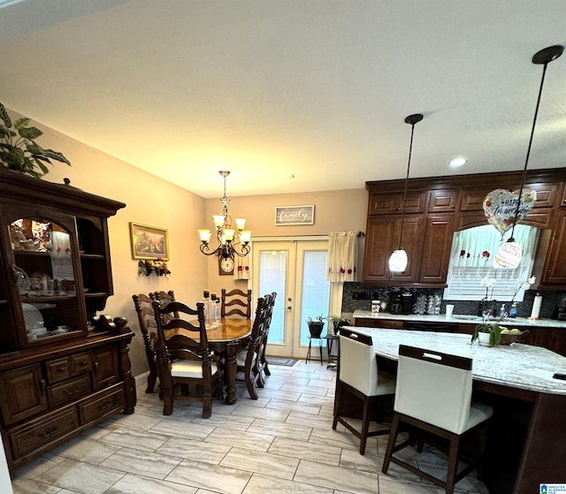 dining area featuring french doors, a chandelier, and sink