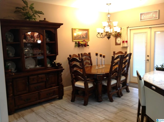 dining area with french doors and an inviting chandelier