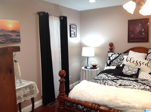 bedroom featuring hardwood / wood-style flooring and an inviting chandelier