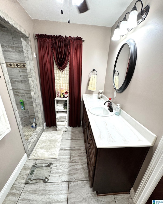 bathroom featuring a tile shower, vanity, and ceiling fan