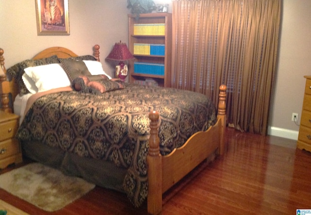 bedroom with dark wood-type flooring