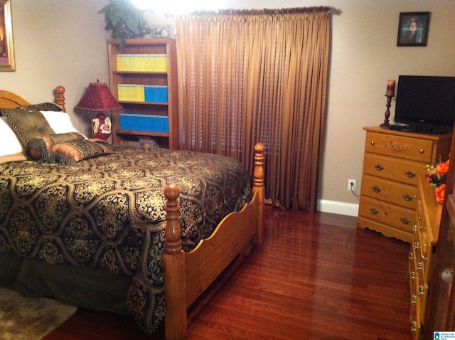 bedroom with dark hardwood / wood-style flooring