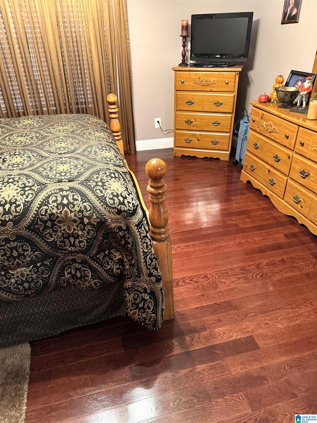 bedroom with dark hardwood / wood-style floors